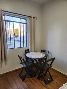 a table and chairs in a room with a window at Quarto central em ótima localização in Curitiba +2 photos