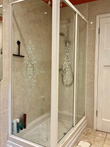 a shower with a glass door in a bathroom at Home Thyme Holding in Upwell