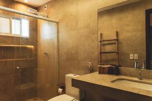 a bathroom with a toilet and a sink and a shower at Casa Mandala - Rooftop com Jacuzzi e Vista Mar in Barra Grande