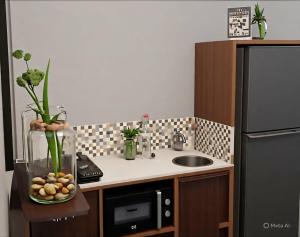 a small kitchen with a sink and a refrigerator at Samal Hillside Inn in Samal +3 photos