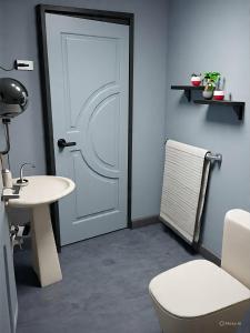 a bathroom with a white door and a table and a chair at Samal Hillside Inn in Samal