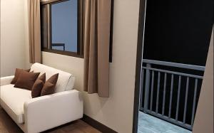 a white couch in a room with a window at Samal Hillside Inn in Samal