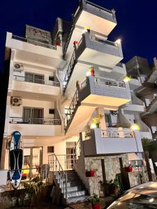 a tall white building with stairs on it at Hotel PEJA in Velipojë