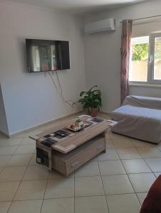 ein Wohnzimmer mit Couchtisch und Bett in der Unterkunft Amygdalos Room in Kómi