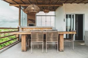 an outdoor dining area with a wooden table and chairs at Casa Mandala - Rooftop com Jacuzzi e Vista Mar in Barra Grande