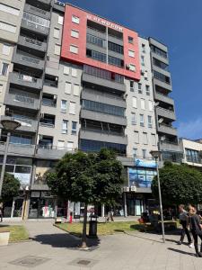 a tall building with people walking in front of it at City-Center Space in Mitrovica