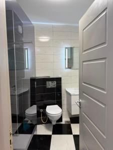 a bathroom with a toilet and a sink at City-Center Space in Mitrovica +9 photos
