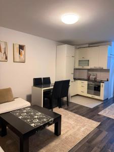 a living room with a table and a kitchen at City-Center Space in Mitrovica
