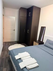 a bedroom with a blue bed with towels on it at City-Center Space in Mitrovica