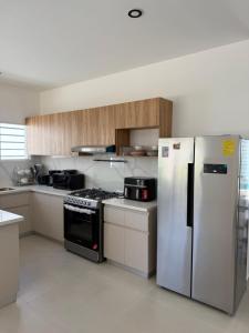 a kitchen with stainless steel appliances and wooden cabinets at Casa Brisas del Sur in San Juan del Sur