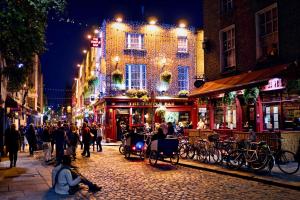 a group of people walking down a street at night at Coopers Lane in Dublin