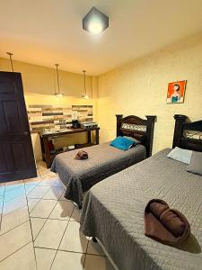 a hotel room with two beds and a desk at Cristales de Antigua Casa Cristal in Antigua Guatemala