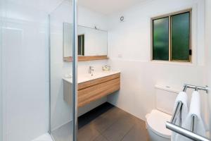 a bathroom with a sink and a toilet and a mirror at Big4 Sydney Lakeside Holiday Park in Narrabeen +98 photos