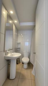 a white bathroom with a sink and a toilet at Apartments Bellas Artes in Santiago +18 photos