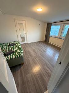 an empty living room with a bed and wood floors at Four bedroom house close to the beach in Abbekås +5 photos