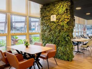 a restaurant with tables and chairs and a green wall at ibis Piracicaba in Piracicaba