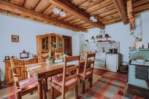 a kitchen with a wooden table and chairs at Babičkina Chalúpka in Pohorelá +49 photos