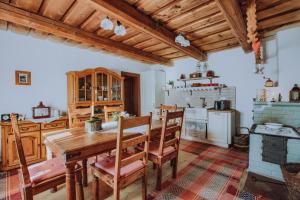 a kitchen with a wooden table and chairs at Babičkina Chalúpka in Pohorelá