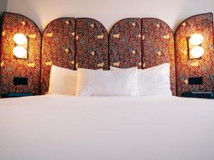a bedroom with a large white bed with a headboard at Ibis Styles Madrid Centro Maravillas in Madrid +106 photos