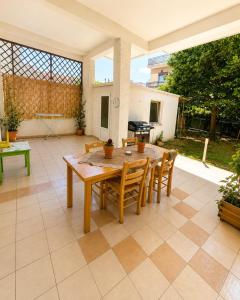 eine Terrasse mit einem Holztisch und Stühlen in der Unterkunft Amaya Pine Central in Chrysoupolis + 13 Fotos