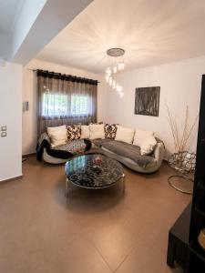 ein Wohnzimmer mit Sofa und Glastisch in der Unterkunft Amaya Pine Central in Chrysoupolis