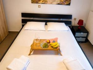 ein Bett mit einem Tablett, auf dem ein Teller mit Obst steht in der Unterkunft Amaya Pine Central in Chrysoupolis