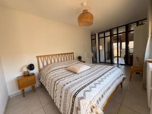 a bedroom with a large bed with a nightstand and window at L'appartement du bonheur - Au Cœur des Volcans d'Auvergne sur la Route du Sud in Issoire +50 photos