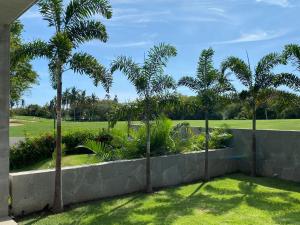 a retaining wall with palm trees in a yard at Anthus Flamingos Condominio 301 in Bucerías