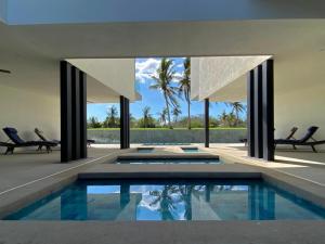 a swimming pool in a house with two chairs at Anthus Flamingos Condominio 301 in Bucerías