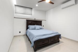 a white bedroom with a bed with blue pillows at Anthus Flamingos Condominio 301 in Bucerías +5 photos
