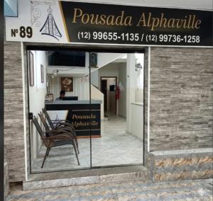 a store front with a chair in front of it at Pousada Alphaville in Aparecida