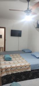 a bedroom with a large bed with blue pillows at Pousada Alphaville in Aparecida +4 photos