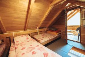 a room with two beds in a wooden cabin at Vikendica Na Plivi E&M in Šipovo