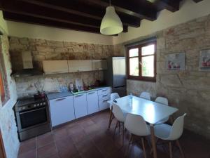 a kitchen with white appliances and a table and chairs at Villas garden&pool in Afitos
