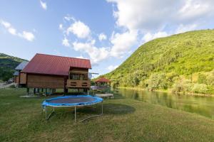 a house next to a river with a trampoline at Vikendica Na Plivi E&M in Šipovo