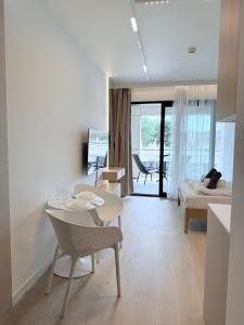 a white living room with a table and chairs at Baltic Infinity Beach Spa in Międzyzdroje