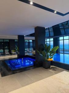 a large swimming pool with a blue tub in a building at Baltic Infinity Beach Spa in Międzyzdroje