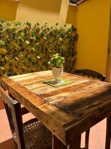 a wooden table with a vase on top of it at la casa del viaggiatore in Bronte +15 photos