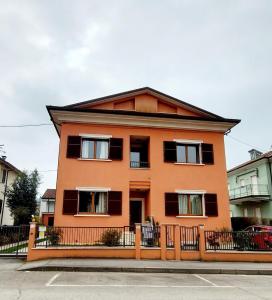 ein orangefarbenes Haus mit einem Mansarddach in der Unterkunft CESENAinCENTRO in Cesena