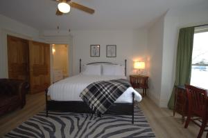 a bedroom with a bed with a blanket on it at Garfield Inn in Port Austin