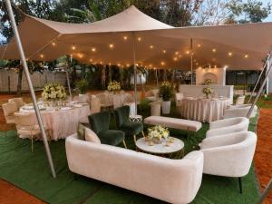 a wedding reception with white couches and chairs under a tent at The Luxury Orchid in Pietermaritzburg