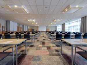 an empty conference room with tables and chairs at Novotel Aachen City in Aachen