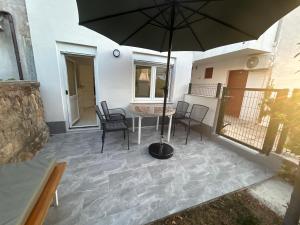 a patio with a table and an umbrella at My Miracle Stinica in Stinica