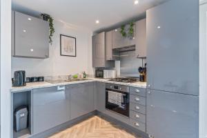a kitchen with stainless steel appliances and white cabinets at The Mersey Sanctuary in Liverpool