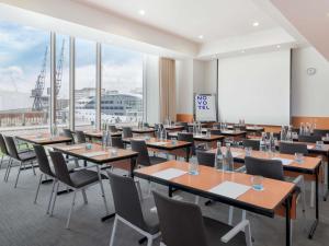 a restaurant with tables and chairs and a large window at Novotel London Excel in London