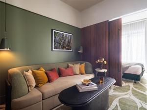 a living room with a couch and a table at Adina Hobart in Hobart +17 photos