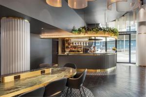 a restaurant with a bar and some chairs at Adina Hobart in Hobart