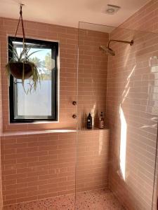 a bathroom with a glass shower with a window at The Royale Bundeena in Bundeena +41 photos