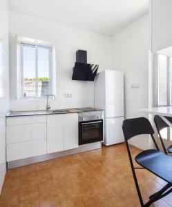 a white kitchen with a sink and a refrigerator at Casa Raxón Ferrol in Ferrol +23 photos