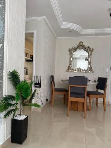 a dining room with a table and chairs and a mirror at Apartamento de Denise in Aracaju